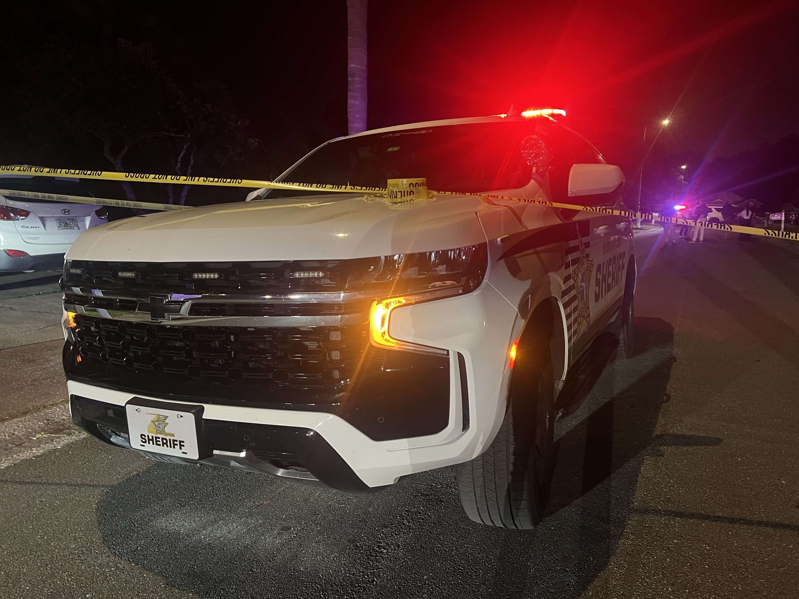 A Hillsborough County Sheriff's Office patrol vehicle is parked outside a residence on Southwick Drive in Tampa, where yellow crime scene tape is visible, indicating an active homicide investigation.