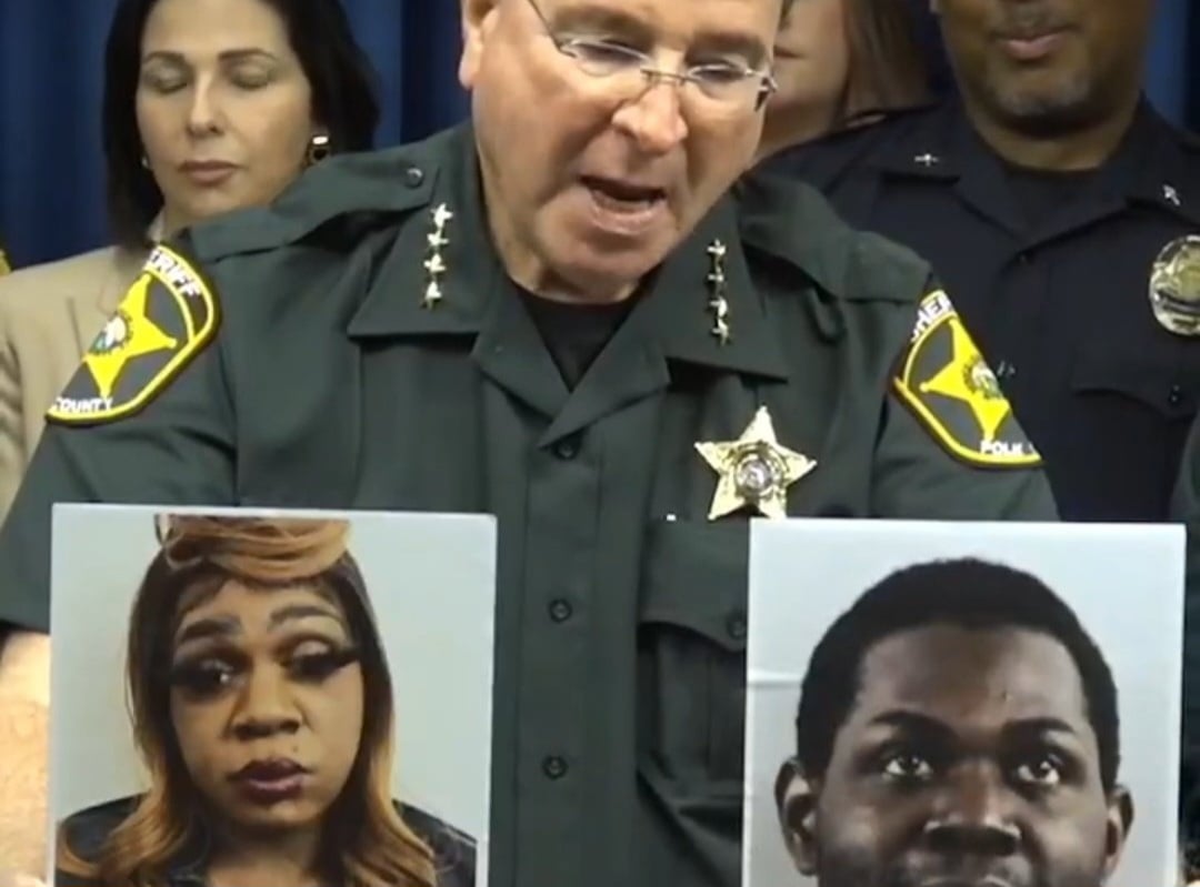 Polk County Sheriff Grady Judd holds up two photos of an alleged cross-dressing prostitute.